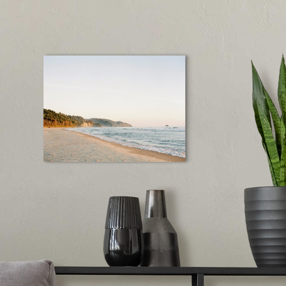 A modern room featuring Photograph of gentle waves lapping a sandy beach.