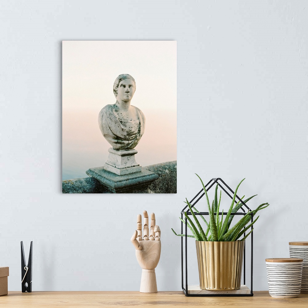 A bohemian room featuring A photograph of a simple, classic bust statue on a stone railing, Lake Como, Italy.