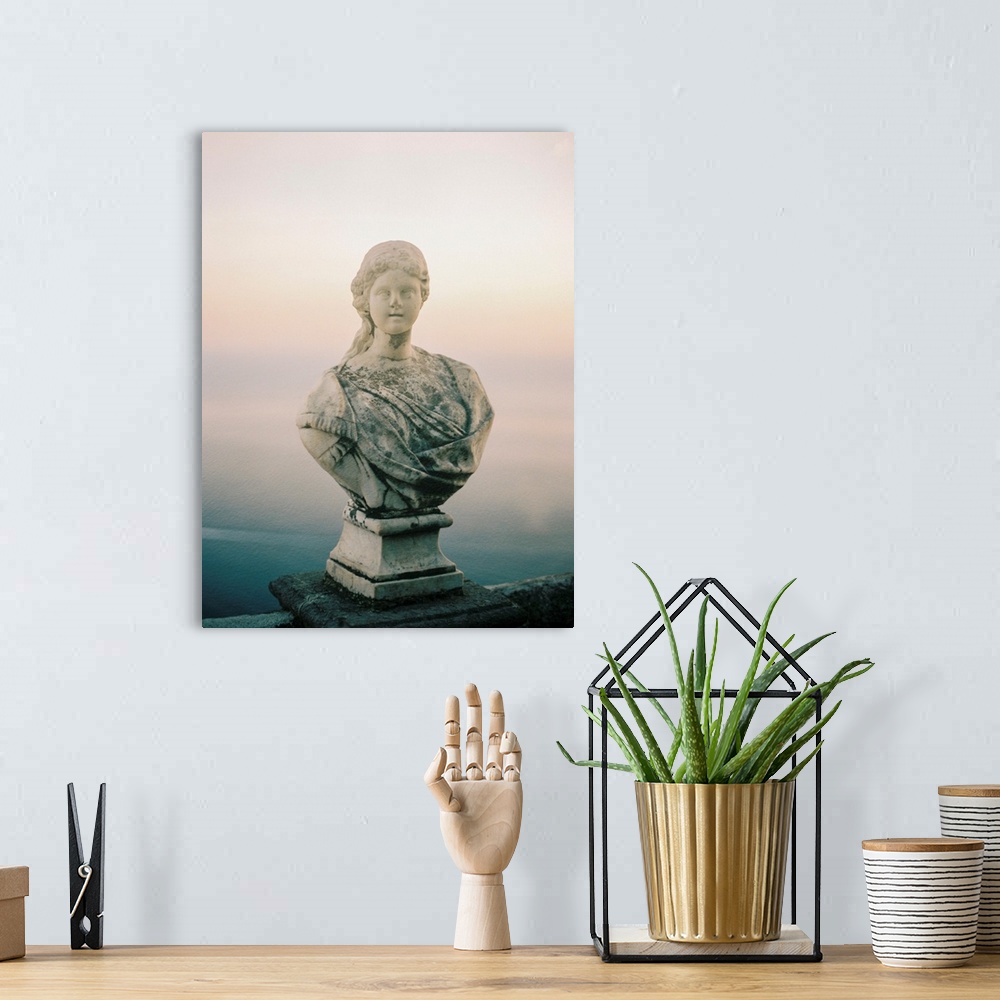 A bohemian room featuring A photograph of a simple, classic bust statue on a stone railing, Lake Como, Italy.