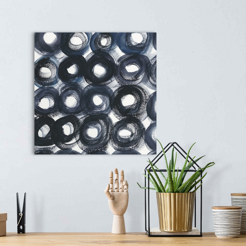 A bohemian room featuring Square abstract decor filled with intense, bold, dark blue circles with white centers and gaps of...
