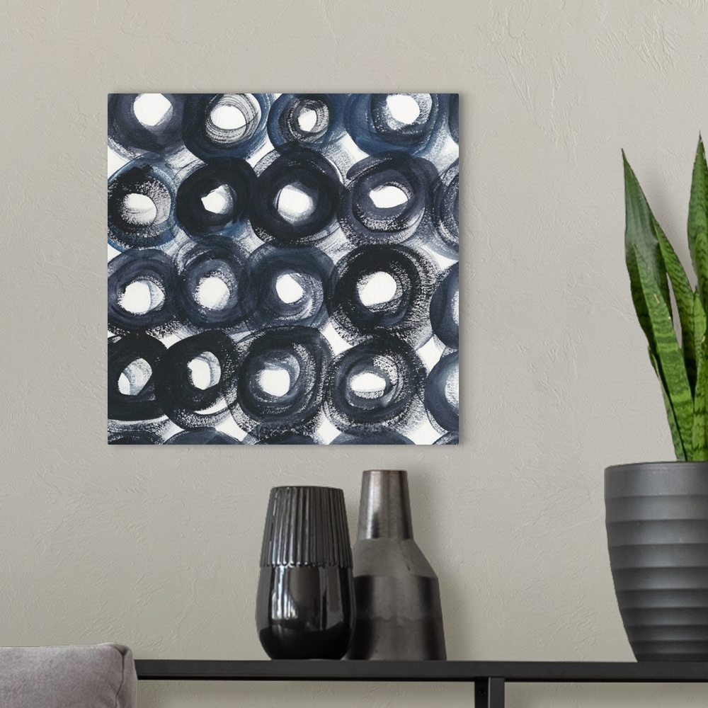 A modern room featuring Square abstract decor filled with intense, bold, dark blue circles with white centers and gaps of...
