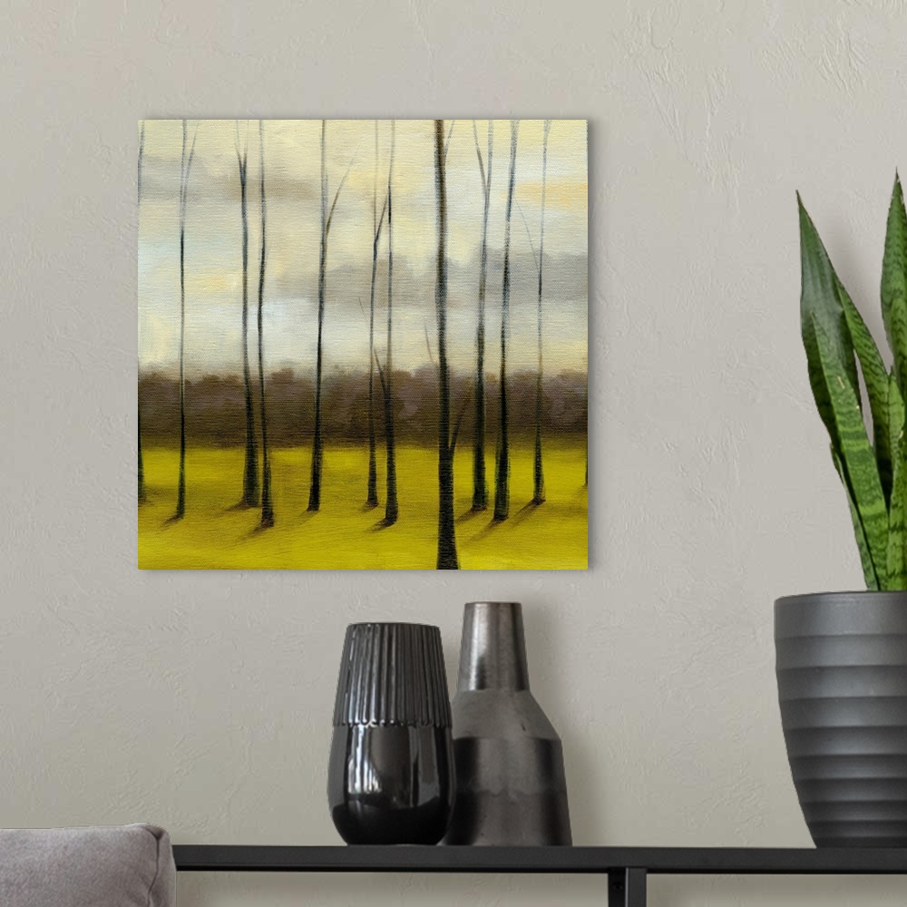 A modern room featuring Contemporary painting of meadow filled with bare trees under a dark cloudy sky.