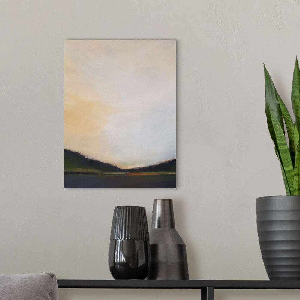 A modern room featuring Vertical landscape painting of a lake with greenery on the horizon and a warm sunset above.