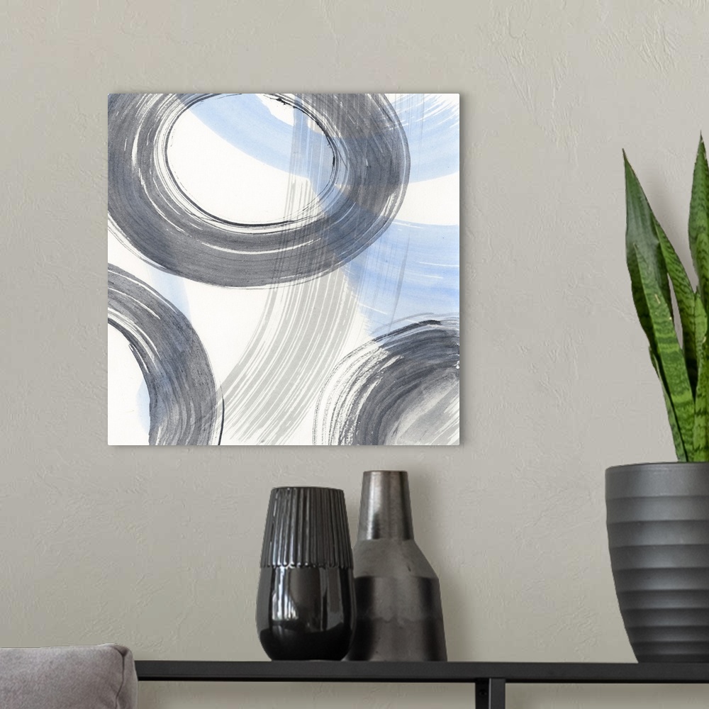 A modern room featuring Contemporary artwork of circular rings accompanied with blue and gray brush strokes.