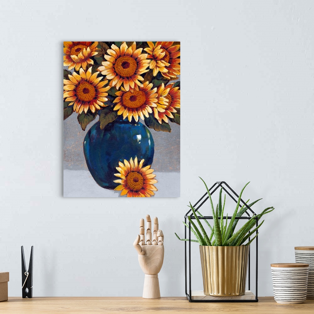A bohemian room featuring A painting of vibrant yellow sunflowers sitting in a deep blue vase against a gray background.