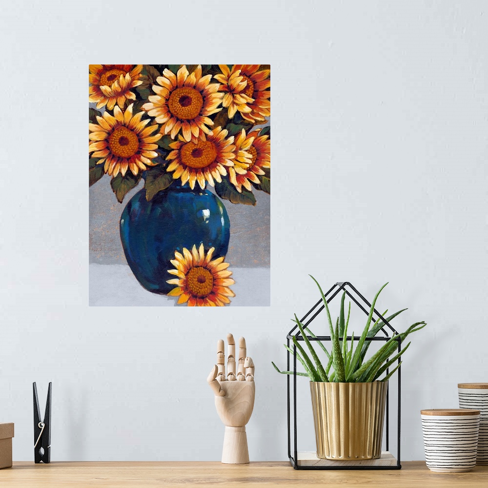 A bohemian room featuring A painting of vibrant yellow sunflowers sitting in a deep blue vase against a gray background.