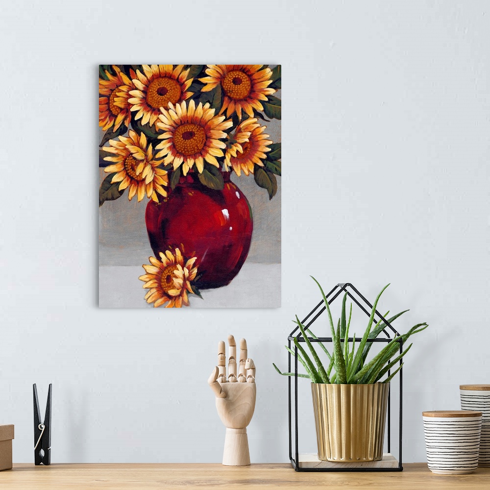 A bohemian room featuring A painting of vibrant yellow sunflowers sitting in a deep red vase against a gray background.