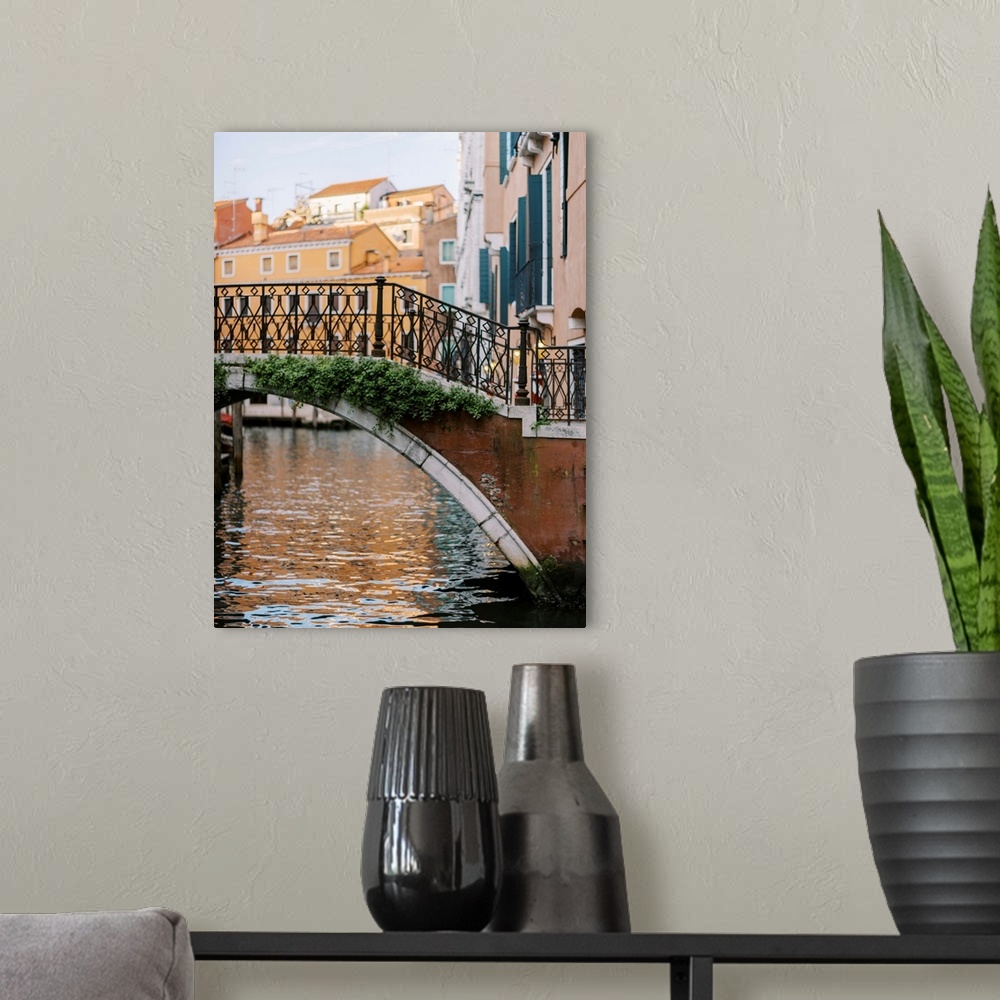 A modern room featuring A photograph of a beautiful wrought iron and stone bridge crossing a canal in Venice, Italy.