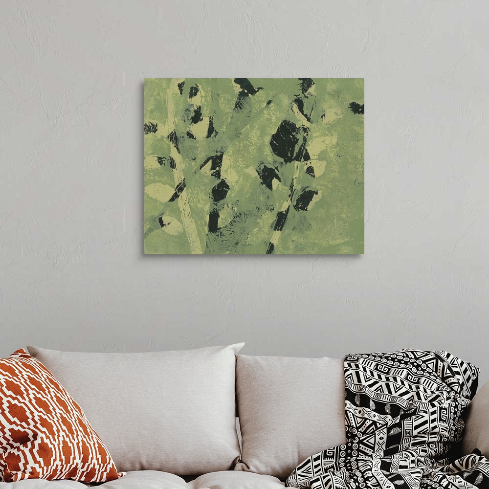A bohemian room featuring Abstract image of shapes similar to leaves on a branch in merging colors of green and black.