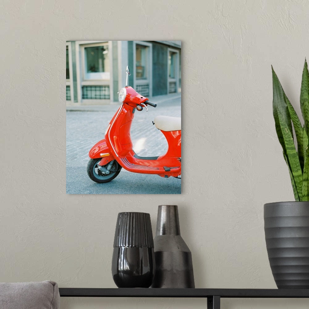 A modern room featuring A photograph of a red scooter parked on the street.
