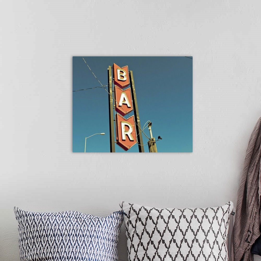 A bohemian room featuring Photograph of mid-century bar sign against a blue sky.