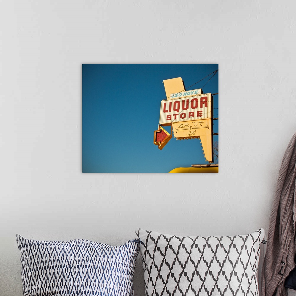 A bohemian room featuring Photograph of mid-century liquor store sign against a blue sky.