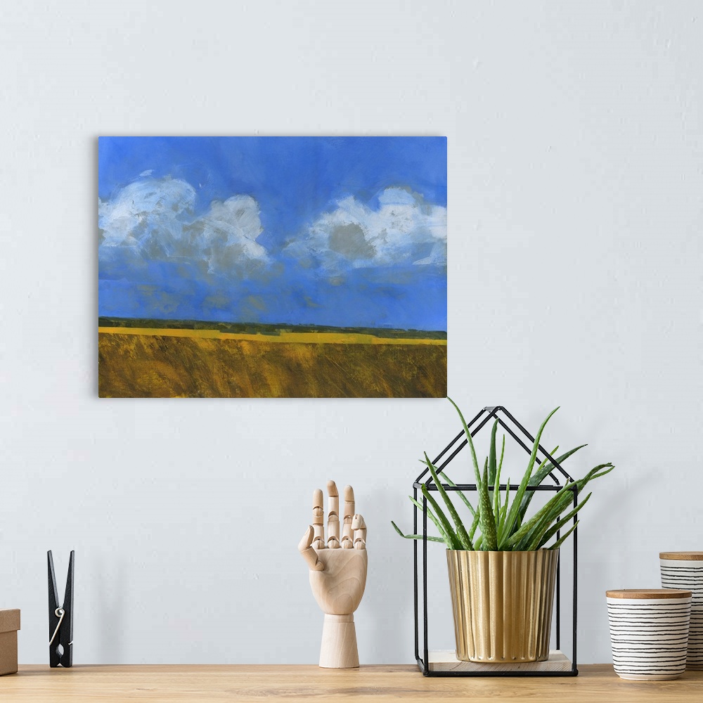 A bohemian room featuring Contemporary painting of an open landscape with a large blue sky with several clouds.