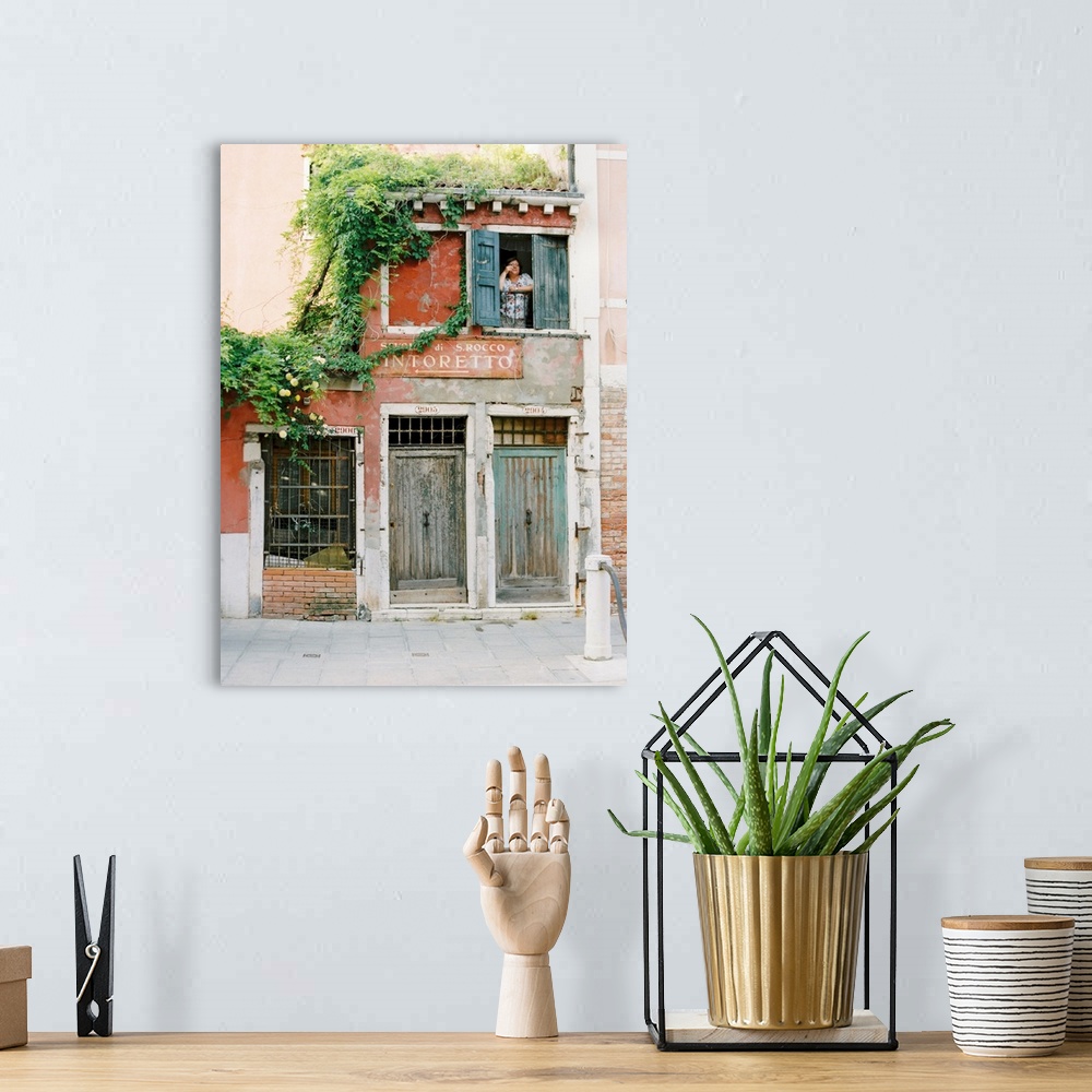 A bohemian room featuring Photograph of a woman looking out of the window of a very old building, Venice, Italy.