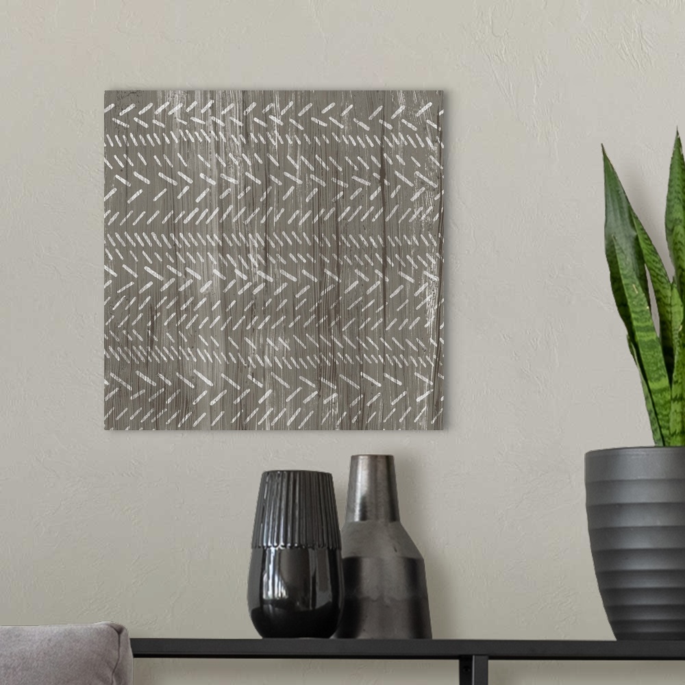 A modern room featuring Square decorative artwork of a repetitive pattern of short angled lines with a light streak overlay.