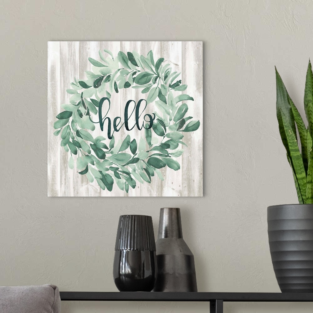A modern room featuring Watercolor wreath painting with script "Hello" in center.