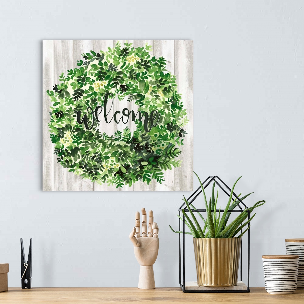 A bohemian room featuring Watercolor wreath painting with script "Welcome" in center.