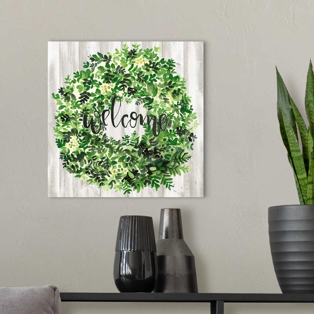 A modern room featuring Watercolor wreath painting with script "Welcome" in center.