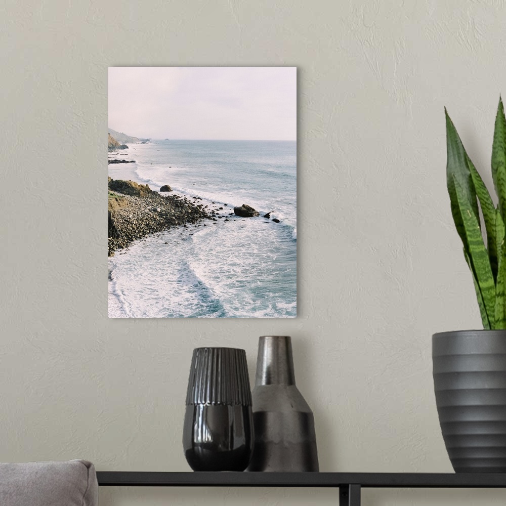 A modern room featuring Photograph of gentle waves lapping the rocky shore of Big Sur, California.
