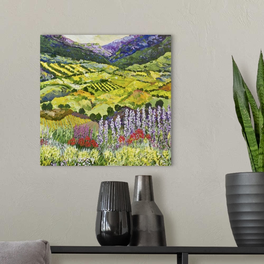 A modern room featuring Contemporary painting of a country landscape with wildflowers in the foreground and farmland in t...