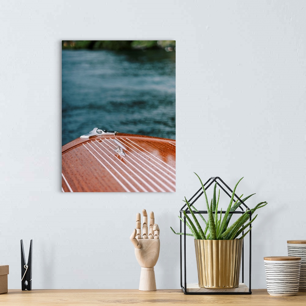 A bohemian room featuring A photograph of the bow of a beautiful wooden motorboat on the water.