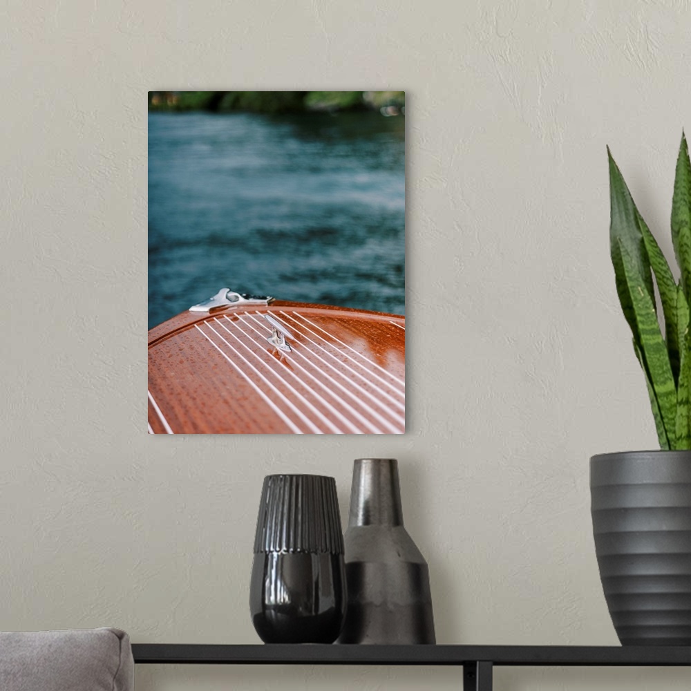 A modern room featuring A photograph of the bow of a beautiful wooden motorboat on the water.