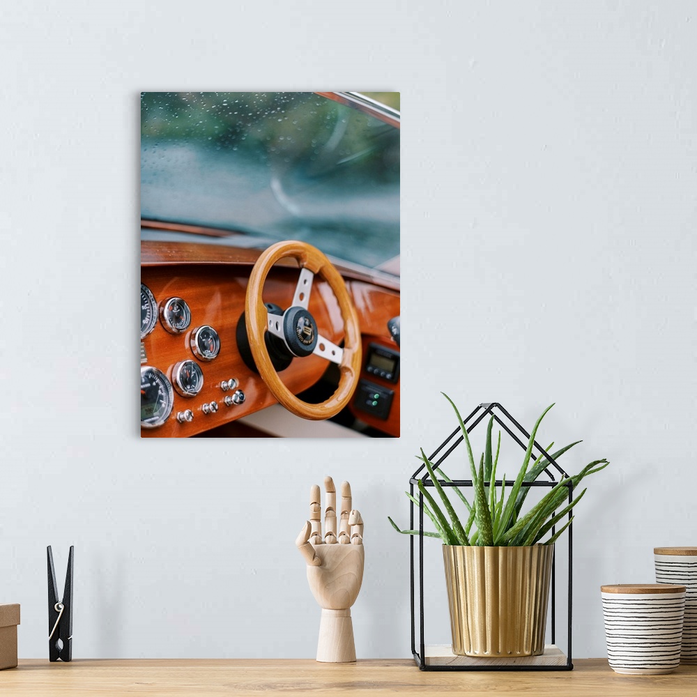 A bohemian room featuring A photograph of the steering wheel and windscreen of a wooden motorboat on the water.