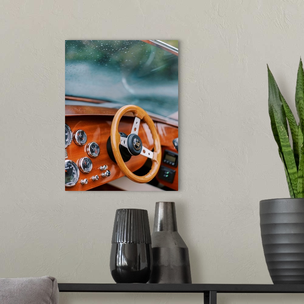 A modern room featuring A photograph of the steering wheel and windscreen of a wooden motorboat on the water.