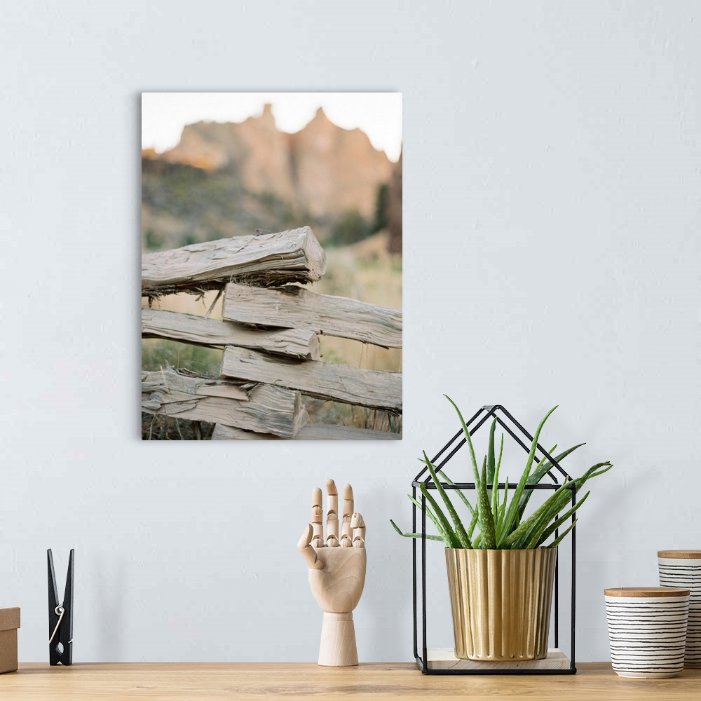 A bohemian room featuring A close up photograph of a rustic split rail fence in front of a large mountain.