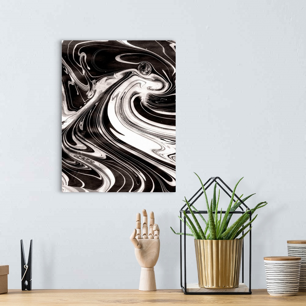 A bohemian room featuring Abstract artwork of black and white paint swirled around in rippling patterns.