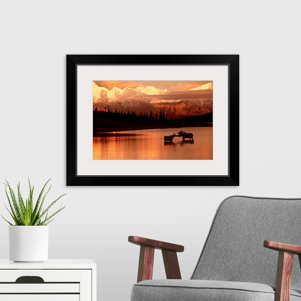 A modern room featuring Landscape photograph of a North American lake and mountains at sunset.