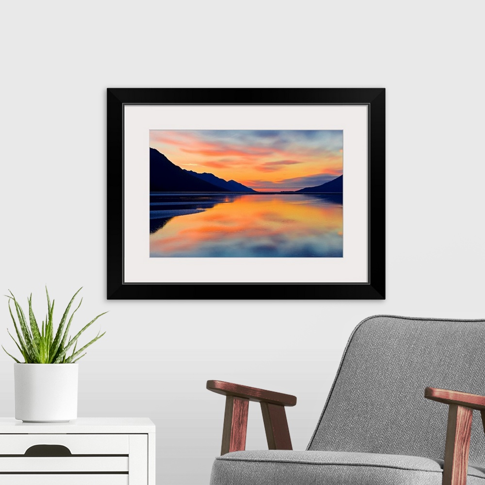 A modern room featuring Expansive photograph of the Turnagain Arm in the Cook Inlet in Alaska (AK) during sunset. Calm wa...