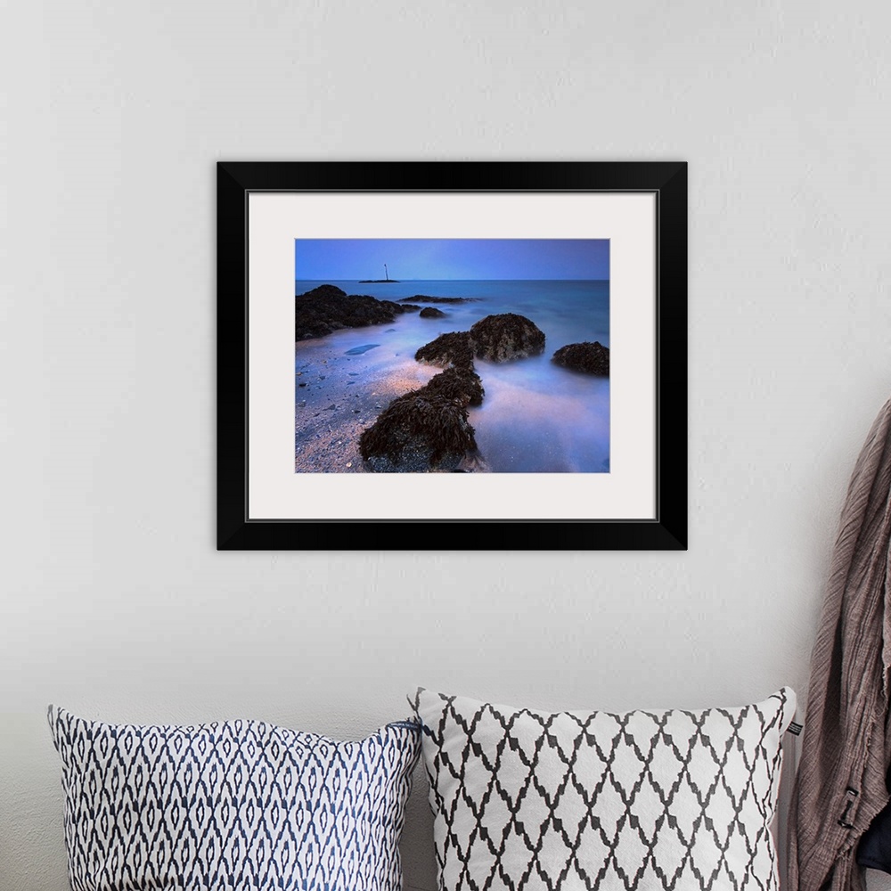 A bohemian room featuring The landscape wall art is a time lapse photograph of waves washing on shore between kelp covered ...