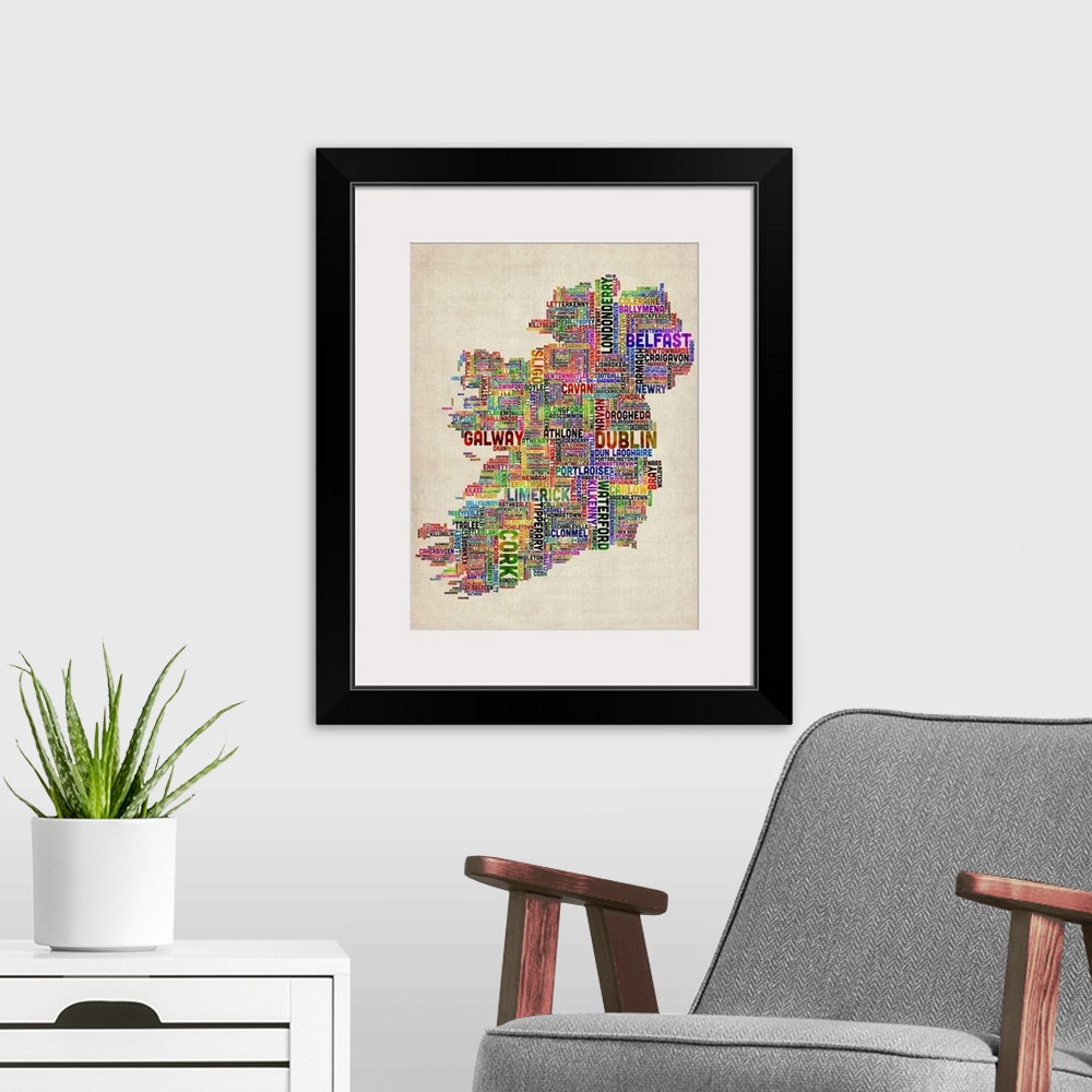A modern room featuring Vertical, big canvas art of Ireland, composed of city names in multiple, bright colors, on a parc...