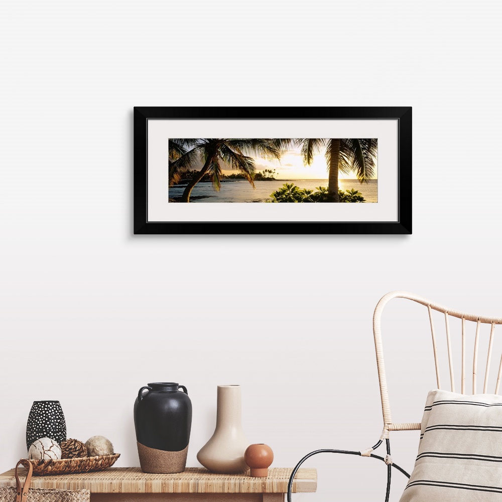 A farmhouse room featuring Panoramic wall art photo for the office or home of the Hawaiian coast; palm trees frame the sun s...
