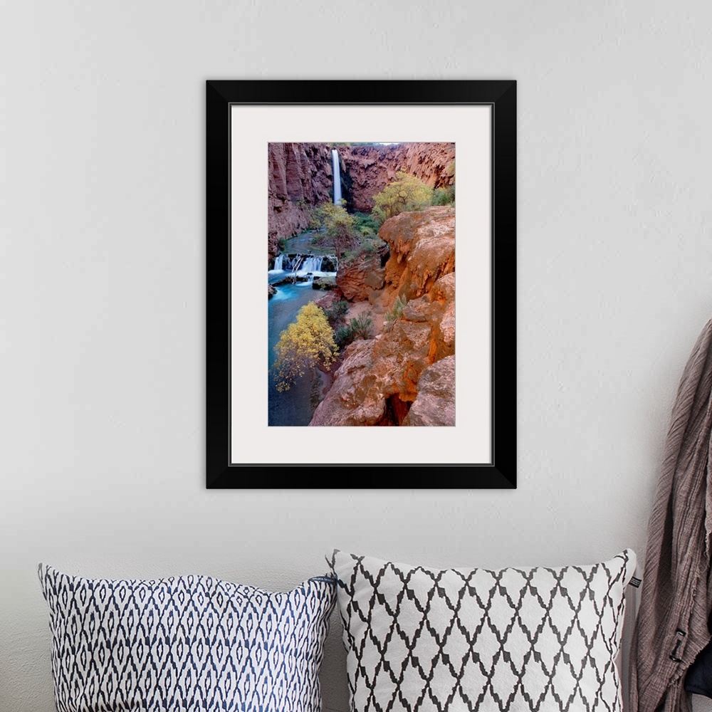 A bohemian room featuring This vertical, landscape photograph shows the waterfall, stream bed, and the plants growing aroun...