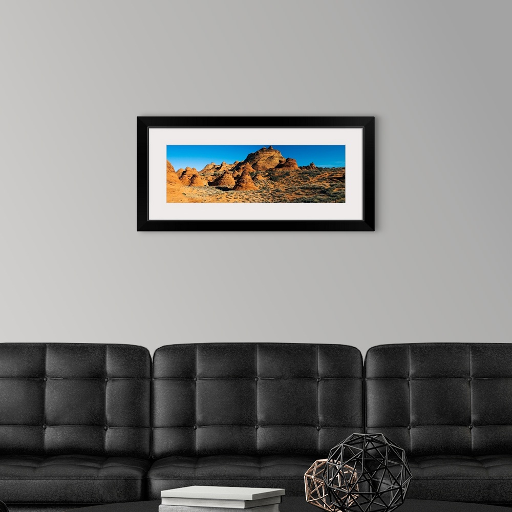 A modern room featuring Panoramic photograph shows a field of rock structures among a dry terrain in the Southwestern Uni...