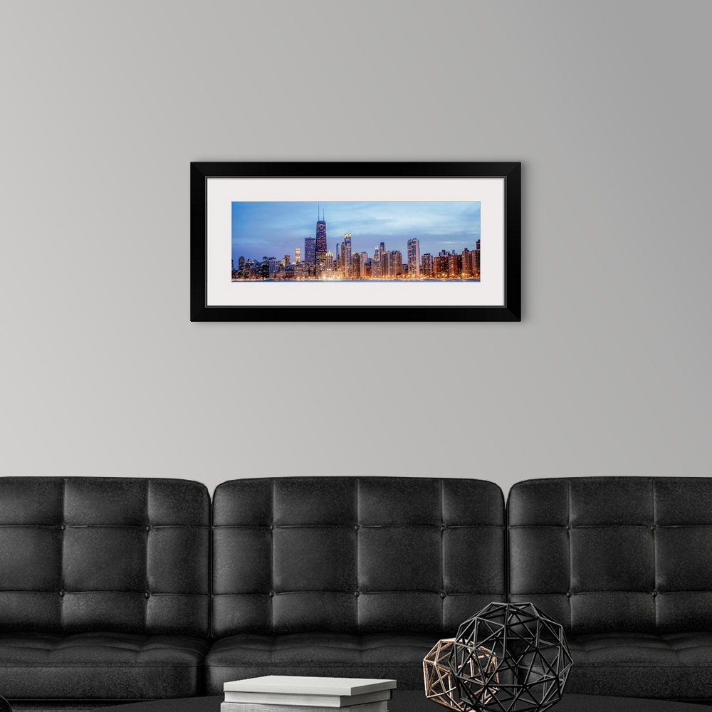 A modern room featuring Panoramic view of the Chicago city skyline illuminated in the early evening, seen from the edge o...