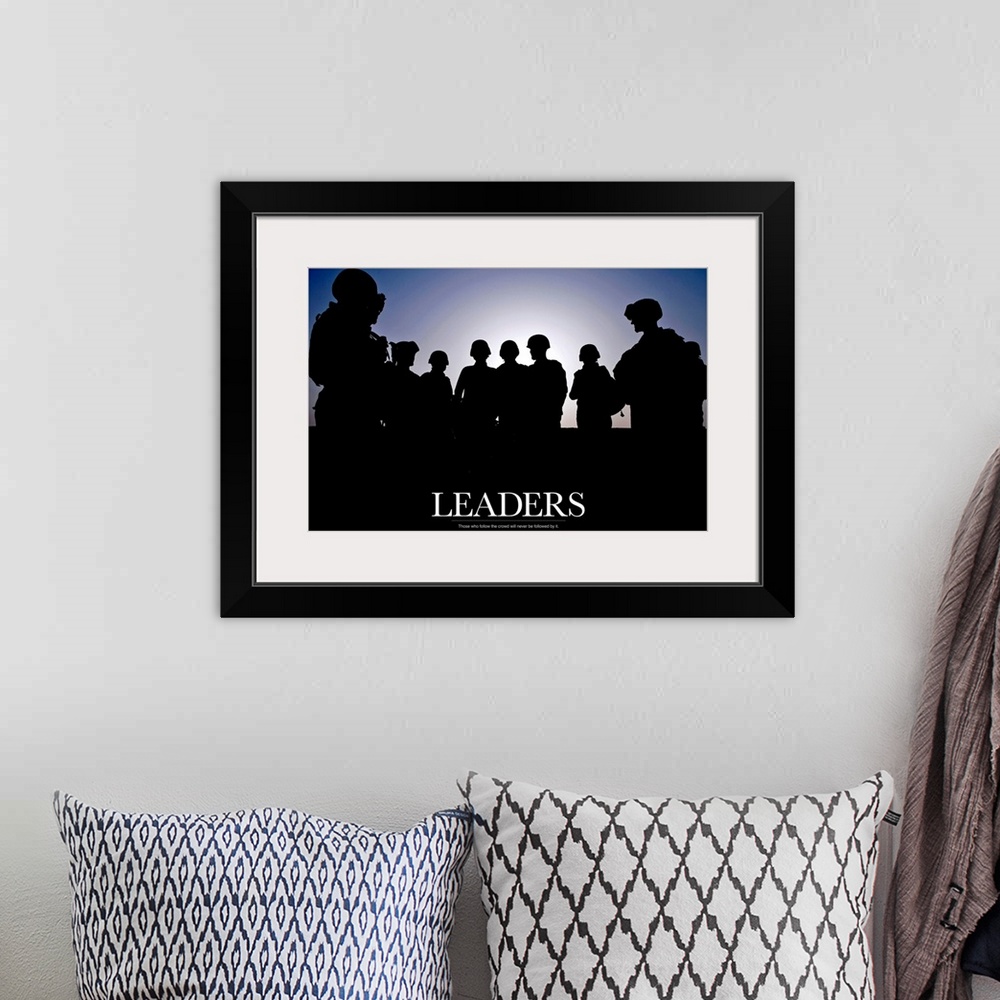 A bohemian room featuring Large photo of the silhouette of soldiers standing against a clear sky with text at the bottom.
