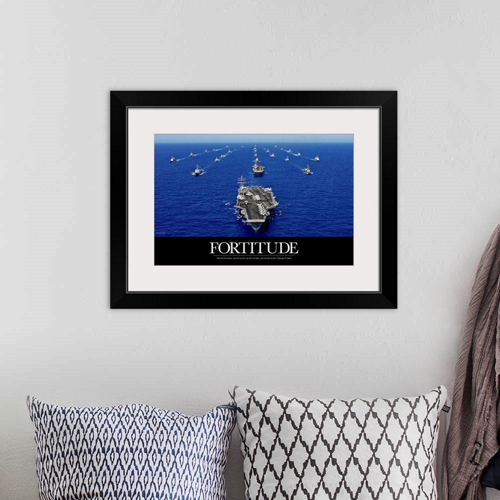 A bohemian room featuring A big piece that is a picture of the navy fleet in the open ocean with the word "Fortitude" below...