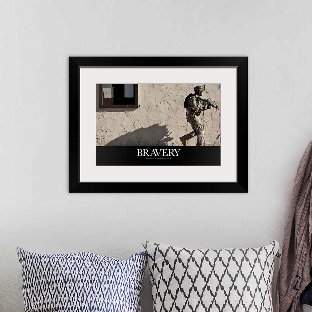 A bohemian room featuring A soldier is photographed walking in front of a concrete wall with his weapon up and the word "Br...