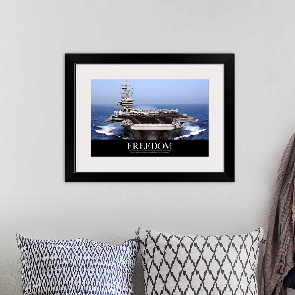 A bohemian room featuring An immense photograph taken of a US navy ship in the open ocean with the word "Freedom" just belo...