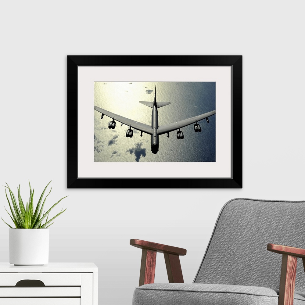 A modern room featuring Horizontal aerial photograph on a  big wall hanging, looking down at the top of a B52 Stratofortr...