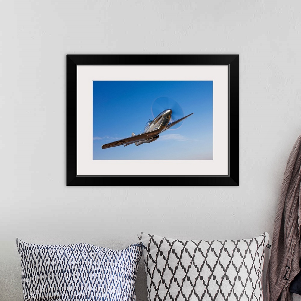 A bohemian room featuring Landscape photograph on a large canvas of a P-51D Mustang in flight, against a bright blue sky ne...