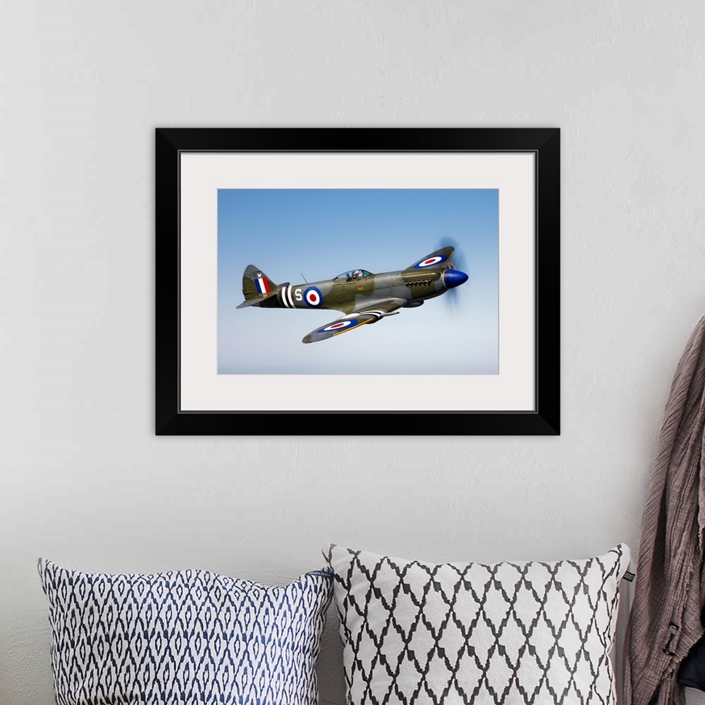 A bohemian room featuring An image of a vintage styled military jet flying through the sky printed on canvas.