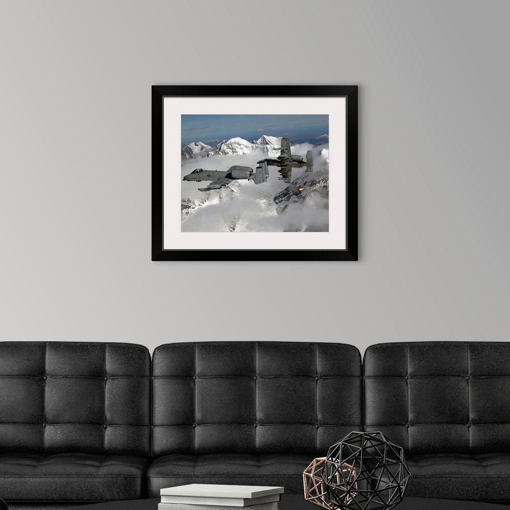 A modern room featuring Big, horizontal photograph of two A10 Thunderbolt IIs flying through the clouds, above snow cover...
