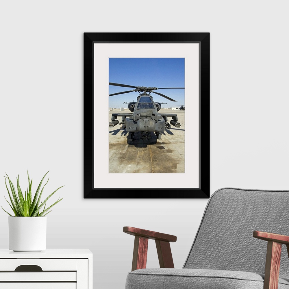 A modern room featuring An AH64D Apache Longbow Block III attack helicopter sits on the flight line