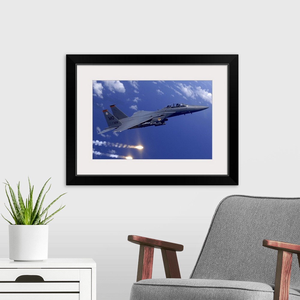 A modern room featuring Photograph taken of a military aircraft flying over water as it shoots flares off the Guam coast.