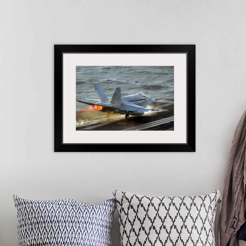 A bohemian room featuring Up-close photograph of jet taking off of an air craft carrier in the ocean.