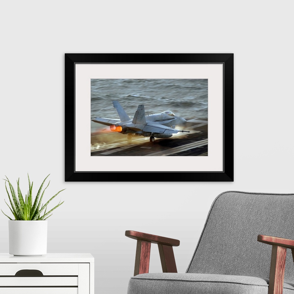 A modern room featuring Up-close photograph of jet taking off of an air craft carrier in the ocean.